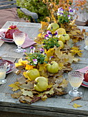 Table decoration with quinces on a carpet of foliage