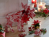 Red and white moose made of papier-mâché with red bow and star