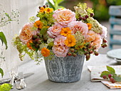 Rural bouquet of roses with tagetes and blackberries