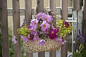 Hanging bag with summer flowers as a welcome to garden gate