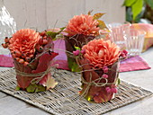 Dahlias wrapped in glasses with berry leaves
