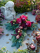 Allerheiligengesteck in Kreuzform : Rosa (Rosen), Protea, gefärbte Beeren