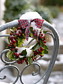 Snow-covered Ilex wreath with checked ribbon