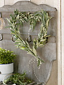 Heart from branches of Olea europaea (olive) on wall shelf