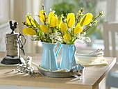 Sträuße in emailierten Kannen aus Tulipa 'Strong Gold' (Tulpen), Spiraea