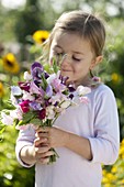Girl with a fragrant bouquet of Lathyrus odoratus (scented vetch)