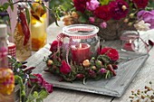 Preserving jar as a lantern with wreath of roses, thyme