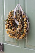 Door wreath of sea buckthorn on blank of dry tendrils