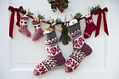 Stuffed Santa Claus socks with red ribbon hung on door