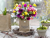 Colorful spring bouquet in paper bag with inscription
