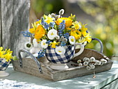 Small spring bouquet in blue-white cup ranunculus, bellis