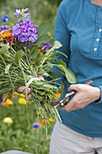 Woman tying colorful summer bouquet