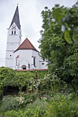 Verwunschene Gartenecke an Mauer zur Kirche