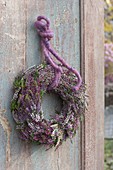 Wreath of Calluna vulgaris (Bud-flowering broom heather) on old wooden door