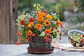 Bouquet of edible flowers and herbs in basket planter