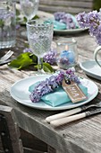 Lilac table decoration with light blue dishes