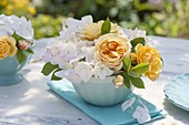 Kleine gelb-weiße Straeusschen aus Rosa (Rosen) und Hydrangea