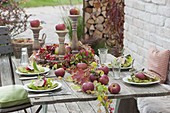Table decoration with apples, rose hips and wild wine
