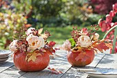 Hollow pumpkins as vases for small bouquets of pink