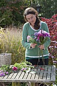 Woman binding autumn bouquet with perennials and grasses