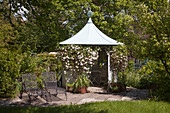 Round pavilion with Clematis montana, lying on a small terrace