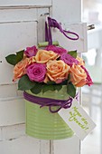 Bouquet made of roses in green tin box with handle on door