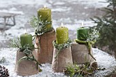 Green candles on upturned terracotta pots, twigs of Pinus