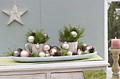 Advent arrangement in cups on bread bowl, decorated with Christmas tree balls