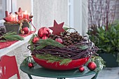 Red bowl with Cornus wreath (dogwood), twigs of Pinus