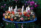 Rosenkranz mit Kerzen auf blauem Tisch