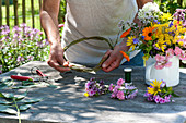 Tying colorful summer flowers wreath