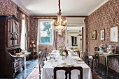 Festively set dining table in dining room with ornate wallpaper