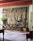 17th century Flemish tapestry and firewood stacked under bench in foyer