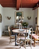 Wooden table, 18th-century Swedish chairs and French mirror above antique sideboard
