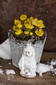 Pot of winter aconites and snowman Christmas tree bauble