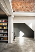 Grey niche, bicycle and bookcase in converted loft apartment