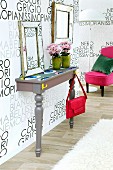 DIY console table against wallpaper with pattern of lettering