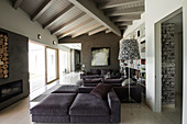 Elegante Lounge mit grauer Polstergarnitur, Kamin und Glasfront