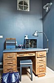 Schreibtisch vor grau-blauer Wand