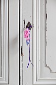 Grape hyacinth and two pink hyacinth florets hung from wardrobe key