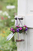 Candle lantern made from mason jar decorated with wreath of asters