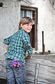 Boy with asters in trouser pocket