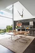 Modern dining table and cantilever chairs next to panoramic window