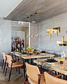 Set dining tables with stone wood marble tops in front of grey wood-clad wall