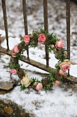 Romantic wreath of ivy leaves and roses in snow
