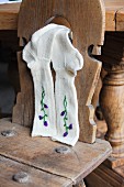 Hand-knitted woollen socks embroidered with flowers hung from farmhouse chair