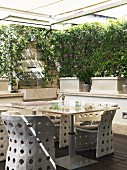 Garden table and woven outdoor chairs on sheltered terrace