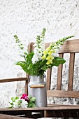 Yellow and white snapdragons in old milk churn