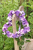 Heart-shaped wreath of hydrangea and phlox flowers on old wooden chair