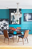 Turquoise wall and crystal chandelier in dining room